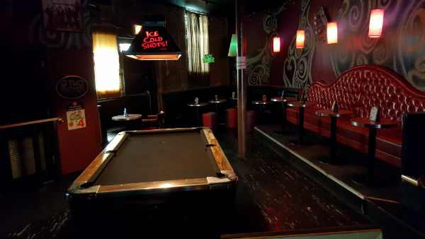 A pool table in the corner of a room.